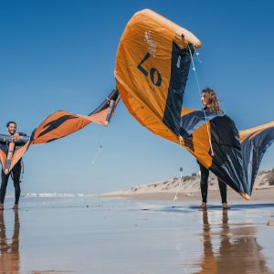 Mustapha et Pauline de Kite Evasion Essaouira sur la plage les ailes de kitesurf à la main