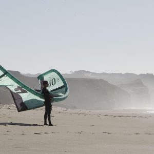 lea de Passaro kite debout sur une plage d'obidos avec une aile de kitesurf dans la main