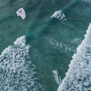 photo en vue aérienne d'un kitesurfeur qui navigue entre les vagues avec du matériel de Magma, une école de kitesurf à Fuerteventura.